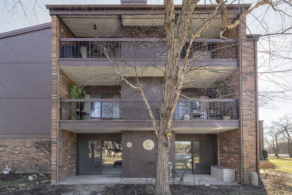Front view of a three-story brick building with balconies.