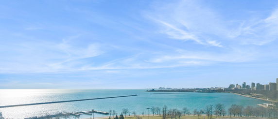 Wide view of a large body of water and a distant skyline under a clear sky.