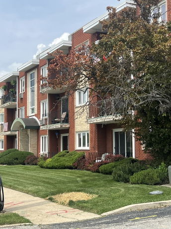Front view of a three-story apartment building with balconies.