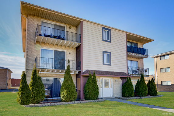 Front view of a three-story residential building with balconies.