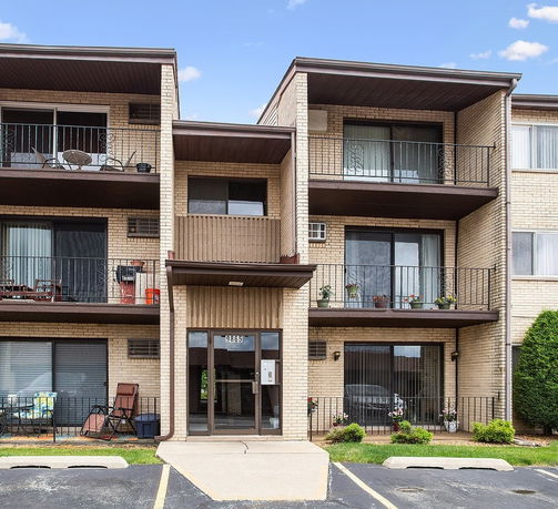 Front view of a multi-story apartment building with balconies.