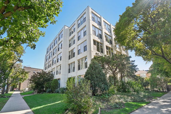Front view of a multi-story building with large windows.