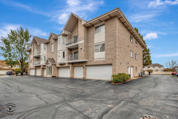 Front view of a multi-story apartment building with garages.