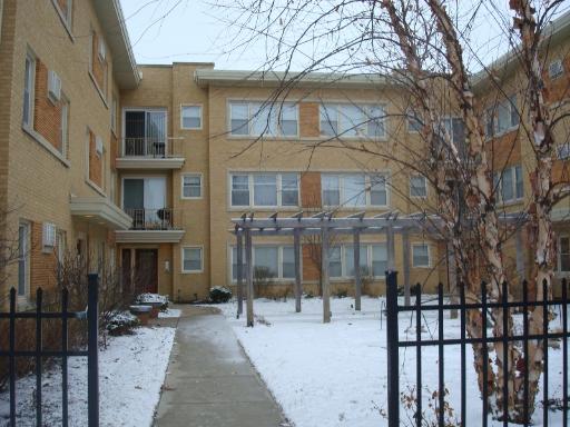 Front view of a multi-story building with a snow-covered courtyard.