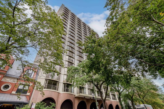 Front view of a tall multi-story residential building with arched entrances.