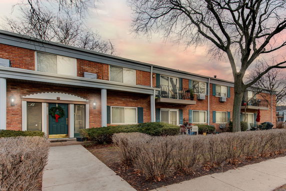 Front view of a two-story brick apartment building with balconies.