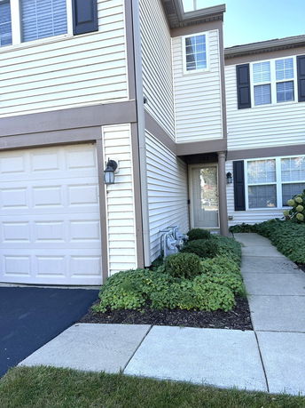 Front view of a two-story house with a garage and pathway.