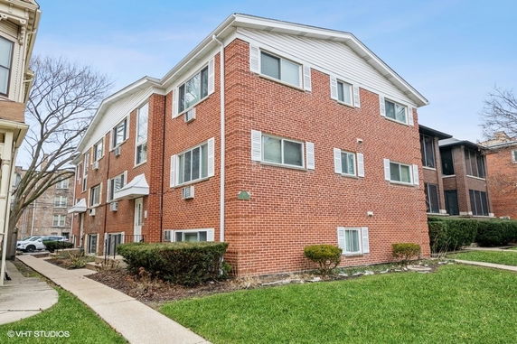 Front view of a brick three-story apartment building.
