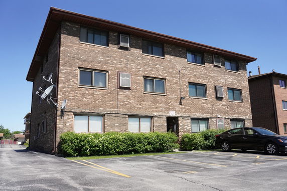 Front view of a three-story brick apartment building.