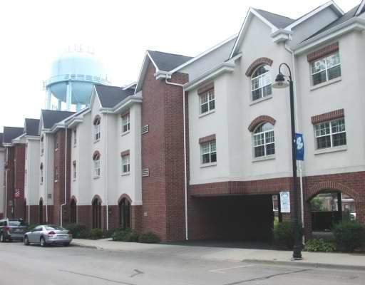 Front view of a multi-story residential building with red brick and white facade.