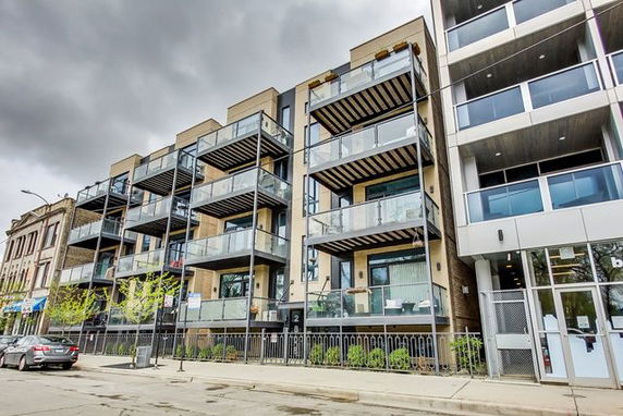 Front view of a modern multi-story apartment building with balconies.