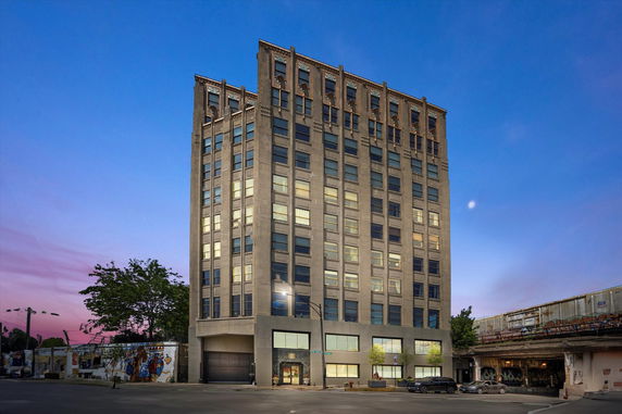 Front view of a multi-story building with a detailed facade at dusk.