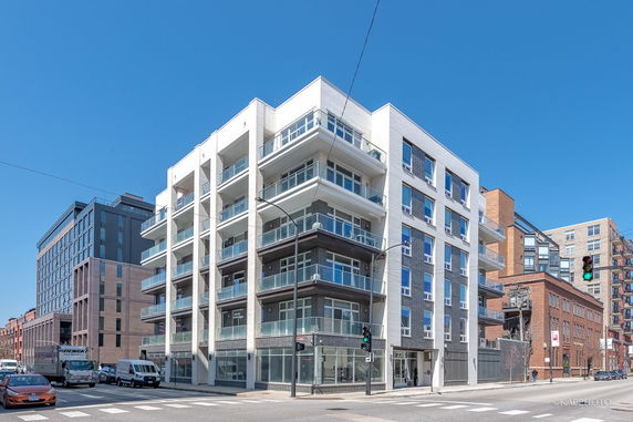 Front view of a modern multi-story apartment building with balconies.