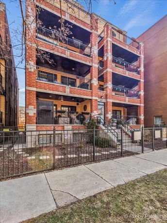 Front view of a multi-story apartment building with balconies.