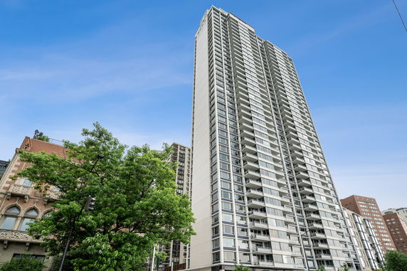 Front view of a tall residential building with multiple balconies.
