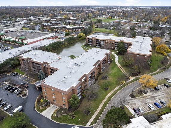 Aerial view of a residential complex with multiple buildings and surrounding area.
