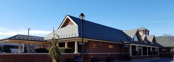 Front view of a single-story brick building with a slate roof.