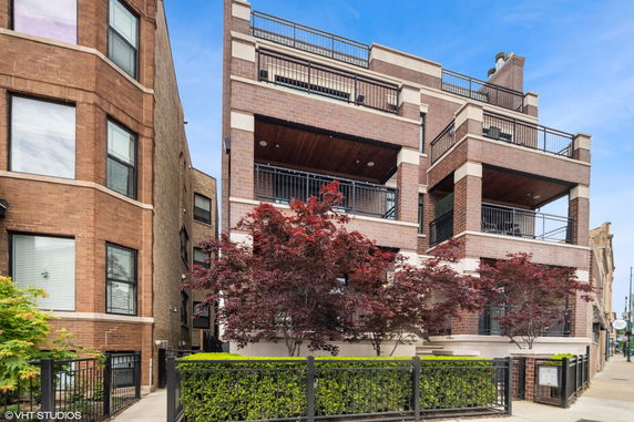 Front view of a multi-story brick building with balconies.
