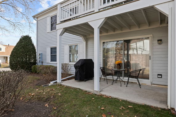 Front view of a two-story house with a balcony and patio.