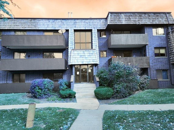 Front view of a multi-story apartment building with balconies.