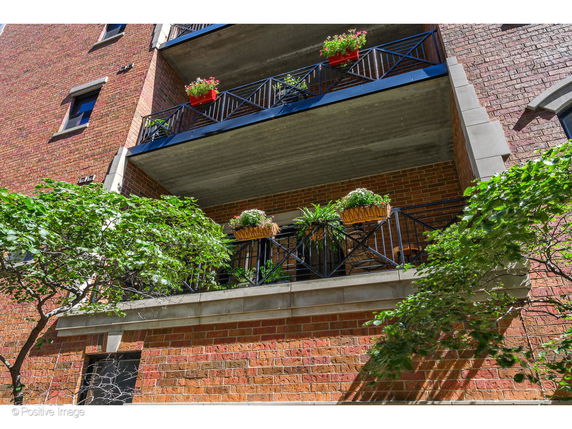 Front view of a brick multi-story building with balconies.