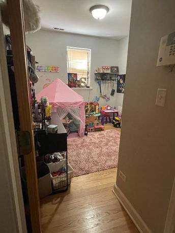 Room with a pink play tent and toys, serving as an indoor play area.