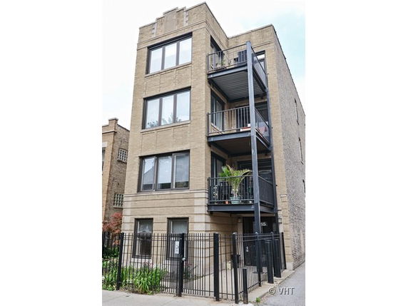 Front view of a multi-story brick building with balconies.