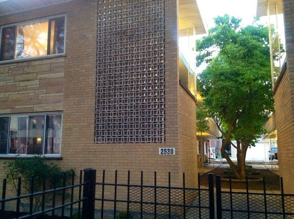 Front view of a multi-story building with decorative facade and windows.