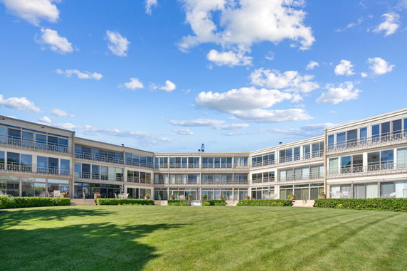 Front view of a large multi-story building with balconies and large windows.