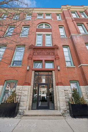 Front view of a multi-story brick building with decorative stone elements.