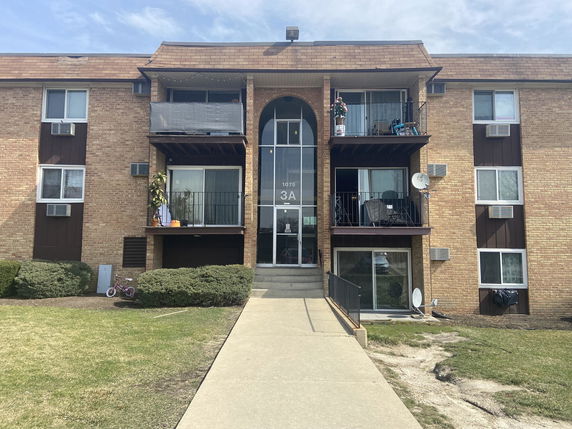 Front view of a multi-story apartment building with balconies.