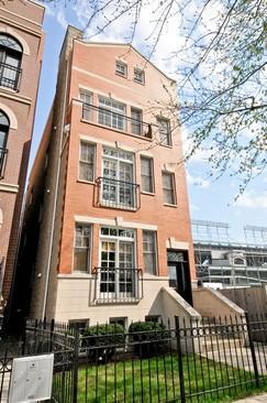 Front view of a multi-story brick building with wrought iron balconies.