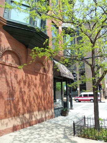 Front view of a brick building with a canopy and windows.