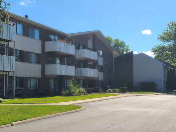 Front view of a multi-story residential building with balconies.