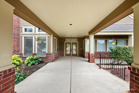 Front view of a building with a covered entrance and brick accents.