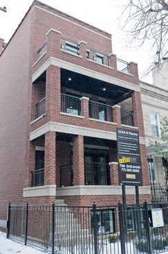 Front view of a multi-story brick building with balconies.