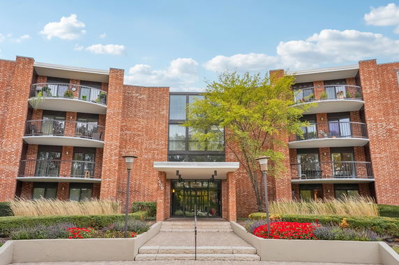 Front view of a multi-story brick building with balconies.