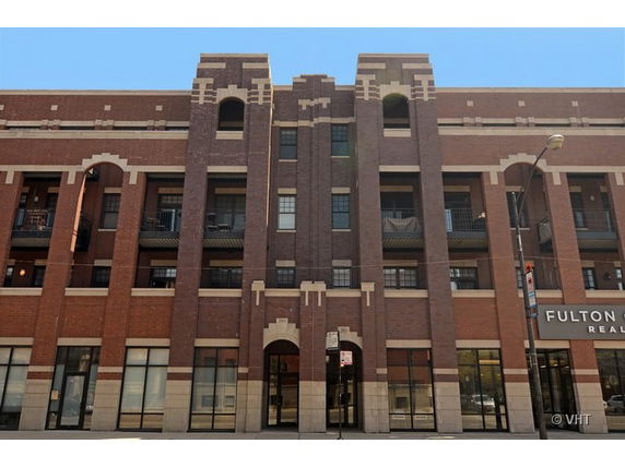 Front view of a multi-story brick building with decorative trim.