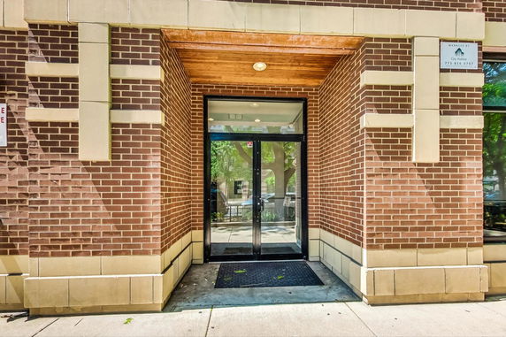 Brick exterior of a building with a glass door entrance.