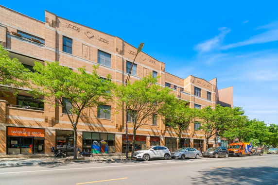 Front view of a multi-story building with ground-level shops.