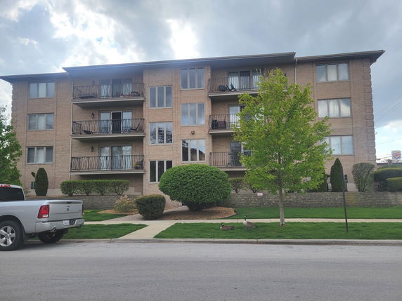 Front view of a multi-story apartment building with balconies.