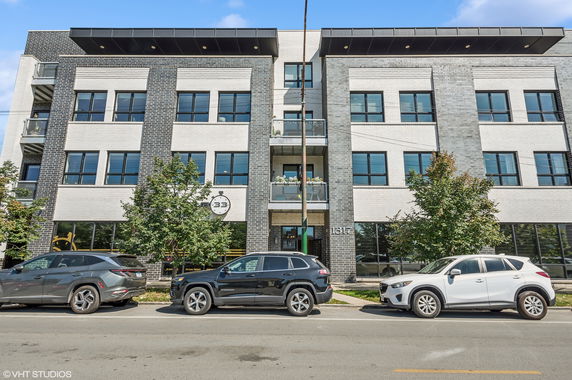 Front view of a modern multi-story building with large windows and a central entrance.