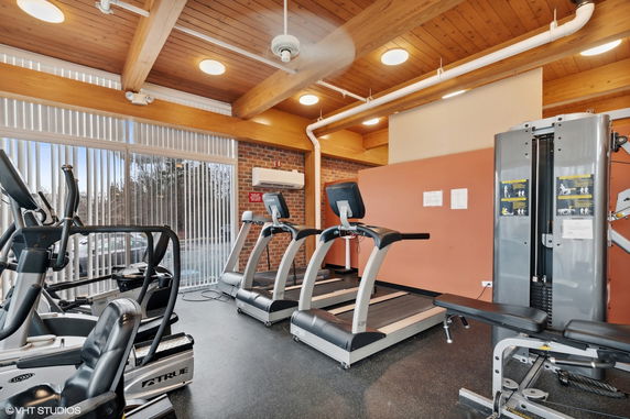 Interior view of a gym with treadmills and weight machines.