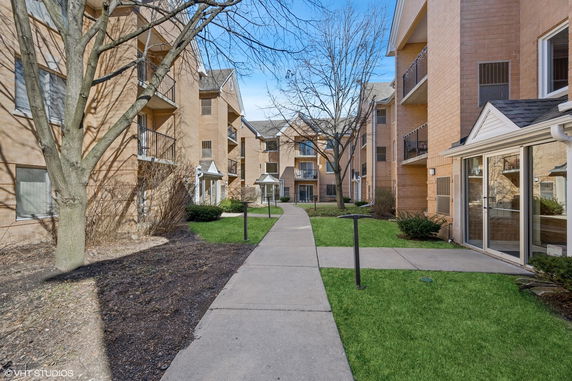 Front view of a multi-story apartment building with brick exterior.