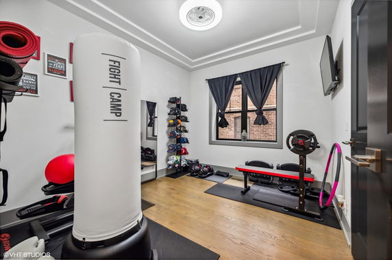 Indoor home gym with workout equipment including a punching bag and weight bench.