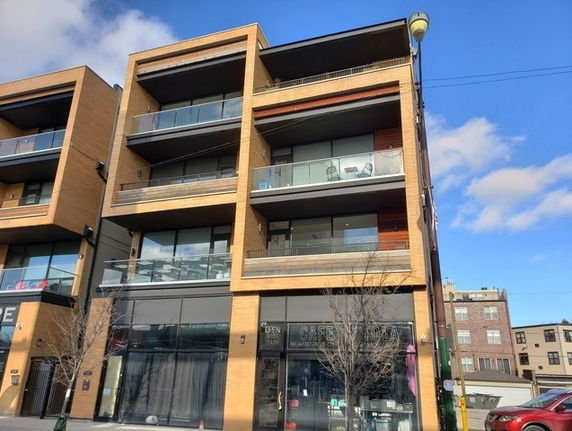 Front view of a multi-story commercial and residential building.