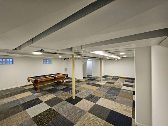 Room with a billiard table and checkered carpet tiles.