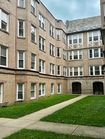 Front view of a multi-story brick building with numerous windows.