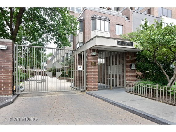 Front view of a multi-story brick building with gated entrance.