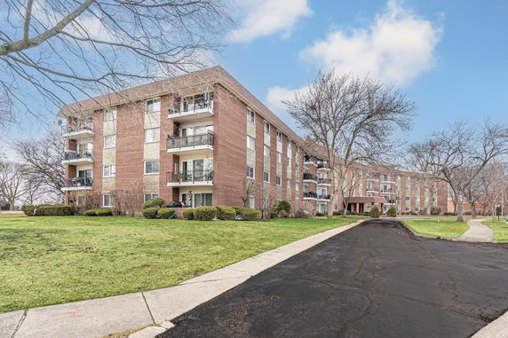 Front view of a multi-story apartment building with balconies.